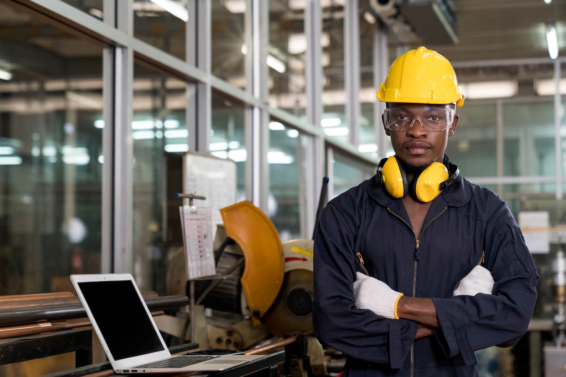 Manufacturing worker. Professional African-American worker controlling the work. Cheerful Factory Worker Posing.